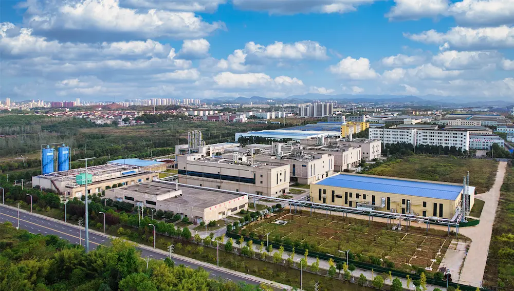 jymedtech-hubei-peptide-manufacturing-facility (2) Aerial view of JYMedtech’s large-scale peptide manufacturing facility in Hubei, China, featuring GMP-compliant buildings and surrounding green infrastructure.
