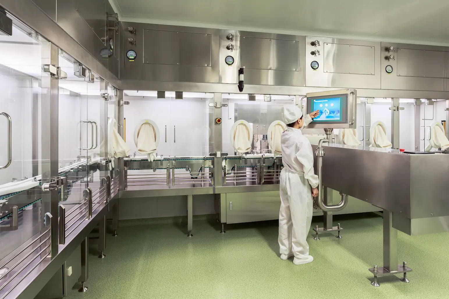 shenzhen-fdf-facility-operator-jymed-peptide.webp Technician in cleanroom suit operating touchscreen control panel inside JYMed Peptide’s Shenzhen FDF facility sterile isolator line.